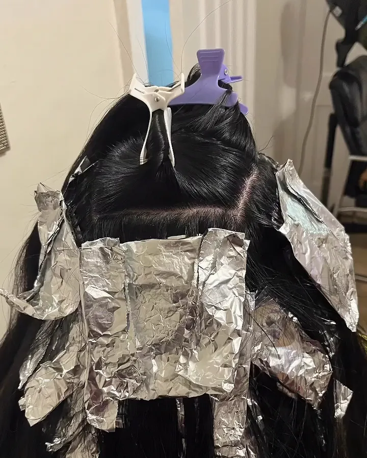 Mechas en proceso con papel aluminio sobre pelo negro